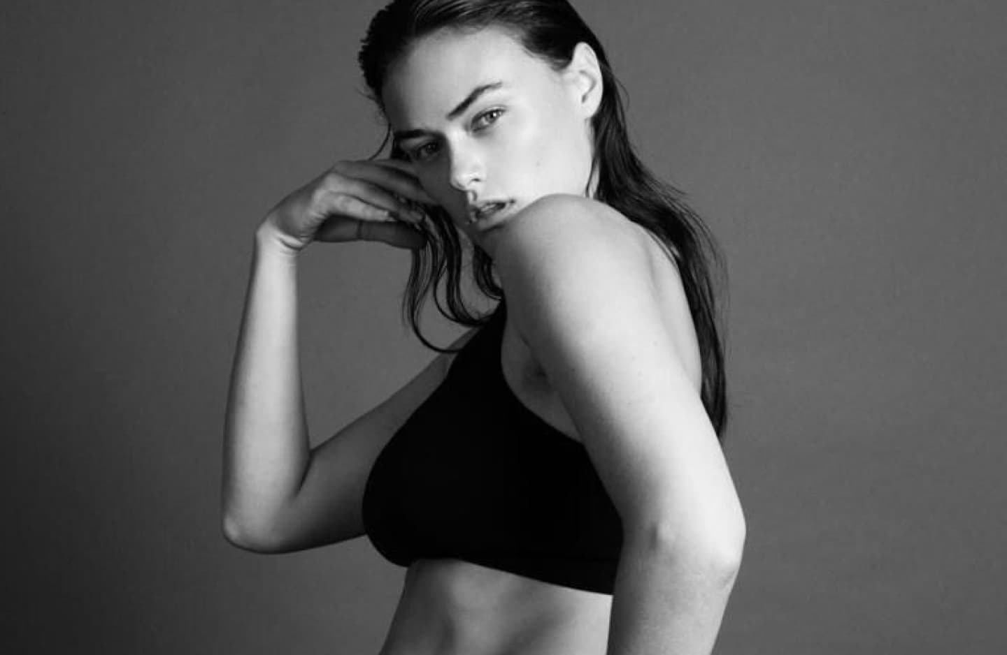A black and white photo of a white woman modelling Calvin Klein underwear.
